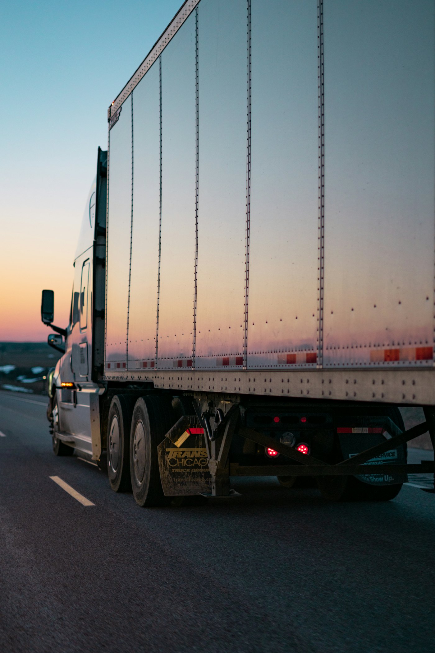 Dry van trailer on the highway at sunset